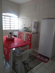 a kitchen with a red table and a refrigerator at Santo Ivo in Aparecida
