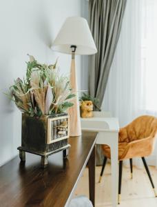 a desk with a lamp and a plant on it at Baltic Sea Dunes Apartments in Jūrmala