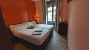 1 dormitorio con 1 cama con paredes de color naranja y ventana en Hostal Corazón de Madrid, en Madrid