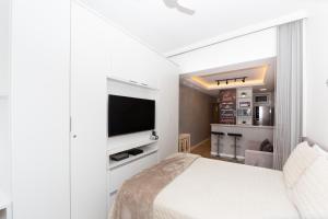 1 dormitorio con 1 cama y TV de pantalla plana en Studio Alaska Copacabana, en Río de Janeiro