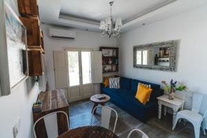 a living room with a blue couch and a table at Lux house with outdoor jacuzzi and sea view in Santorini in Emporio Santorini