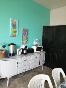 a kitchen with a white dresser with a microwave on it at La Casa Azul in Alajuela