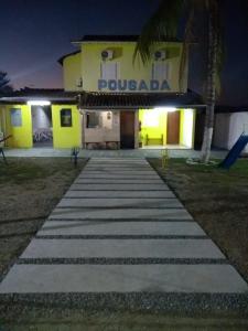 a walkway in front of a building at night at Pousada Guadalupe in Aparecida