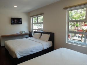 瓜埠的住宿－名古屋酒店，一间卧室设有两张床和两个窗户。