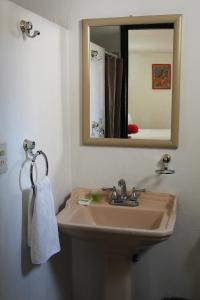 a bathroom with a sink and a mirror at Villas del Sol Hotel & Bungalows in Oaxaca City