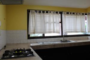 a kitchen with a sink and a window at Villas del Sol Hotel & Bungalows in Oaxaca City