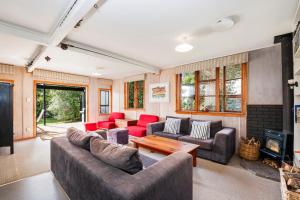 a living room with couches and a fireplace at Tongariro Adventures The Lodge in Kuratau