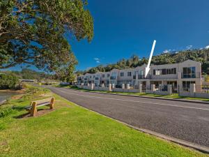 een straat met een gebouw aan de kant van een weg bij Tairua Waterfront Retreat - Tairua Apartment in Tairua