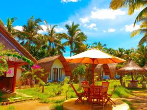 a table with an umbrella in front of a house at Lempeh Jungle Cottage in Nusa Penida