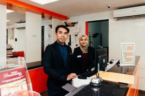 a man and a woman standing in front of a computer at Kertih Damansara Inn in Kertih