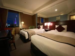 a hotel room with two beds and a view of the eiffel tower at Hotel Trusty Tokyo Bayside in Tokyo