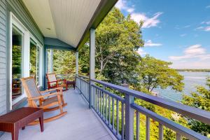 a porch with two chairs and a bench on it at Fanta Sea Shores in Wiscasset