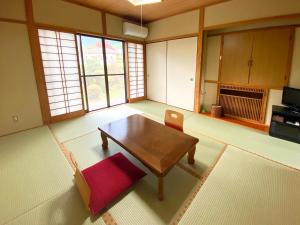 sala de estar con mesa de madera y silla en Yufuin Onsen Hasuwa Inn, en Yufu
