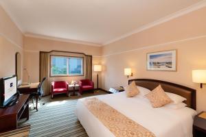 a hotel room with a large bed and a desk at Metropark Lido Hotel Beijing in Beijing