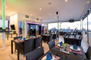 Un restaurante con mesas y sillas con vistas. en Grand Sunset Hotel Phuket, en Karon Beach