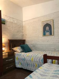 1 dormitorio con 2 camas, vestidor y una foto en Sonrisa Campestre, en Piriápolis
