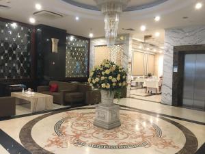 un vestíbulo con un jarrón de flores en el suelo en A25 Hotel - 63A Phương Liệt, en Hanói