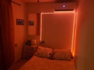 Aché Tropical Studio@white-Red في سان خوان: غرفة نوم مع سرير مع أضواء على الحائط