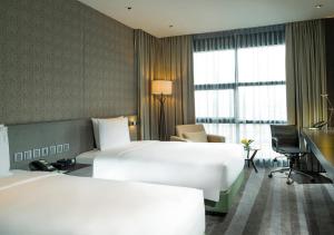 Habitación de hotel con 2 camas y escritorio en Holiday Inn Bangkok Sukhumvit, an IHG Hotel, en Bangkok