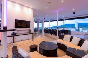 Una sala de estar con un sofá y un televisor. en Grand Sunset Hotel Phuket, en Karon Beach