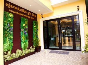 un edificio con plantas a su lado en USABAI Riverside Boutique Hotel en Chanthaburi