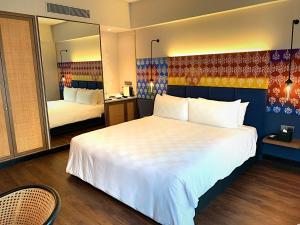 a hotel room with a large bed and a mirror at Hotel Maya Kuala Lumpur in Kuala Lumpur