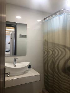 a bathroom with a sink and a shower at Karidis Hotel in Kamari