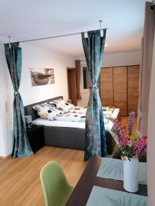 Una habitación con una cama y una mesa en una habitación en Bergperle Apartments & Mountain Sport, en Fliess