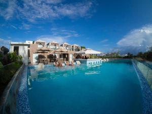 a resort swimming pool with people in the water at Boracay Uptown in Boracay