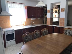 a kitchen with a wooden table and a table and chairs at Panoráma Apartman Ház in Pannonhalma