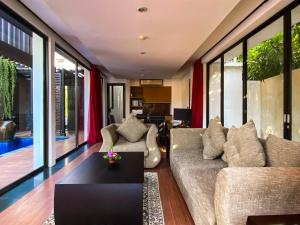 a living room with a couch and a table at Puri Hiromi Boutique Residence in Sanur