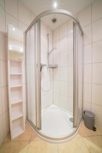 eine Dusche mit Glastür im Bad in der Unterkunft Südstrandhus Urlaub mit Hund Wohnung 2 unten in Borkum