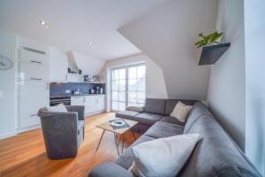 ein Wohnzimmer mit einem Sofa und einem Tisch in der Unterkunft Südstrandhus Urlaub mit Hund Wohnung 4 oben in Borkum