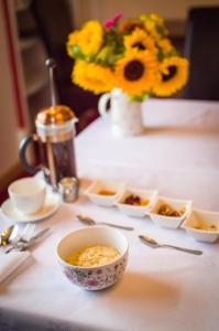 una mesa con tazones de comida y un jarrón de flores en Aden House Bed And Breakfast en Mintlaw