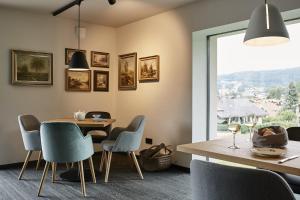 una sala da pranzo con tavolo, sedie e finestra di Winterfeld Guest House Bodenmais a Bodenmais