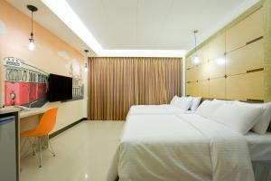 um quarto de hotel com duas camas e uma secretária em Dong Men Hotel em Taipei