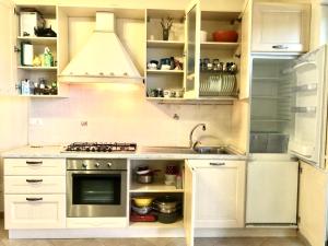 ペダーゾにあるAppartamento mare Marcheの白いキャビネットとシンク付きのキッチン