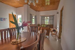 a dining room with a table with a vase of flowers on it at Pascalo Villa Apartment in Mahe