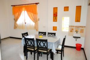 ein Esszimmer mit einem Tisch, Stühlen und einem Fenster in der Unterkunft Villa16Hikkaduwa in Hikkaduwa