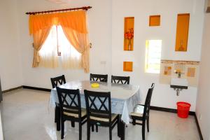 a dining room with a table and chairs and a window at Villa16Hikkaduwa in Hikkaduwa