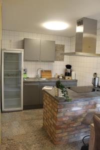 a kitchen with stainless steel appliances and a brick wall at Vorsicht Hôtel in Deyelsdorf