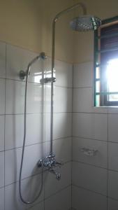 a shower with a shower head in a bathroom at Jojo's Palace Annex in Gulu