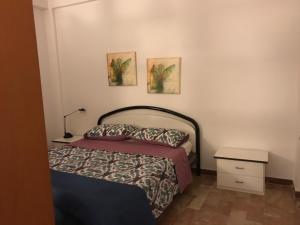 ein Schlafzimmer mit einem Bett und zwei Bildern an der Wand in der Unterkunft Holiday Nizza House in Nizza di Sicilia