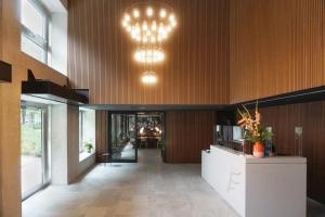 a lobby of a building with a reception desk and chandeliers at THE FLAG West M. in Frankfurt