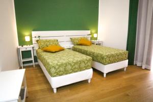 twee bedden in een kamer met groene muren bij Corte Barone in Bari