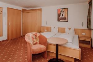 Pokój hotelowy z łóżkiem, krzesłem i stołem w obiekcie Gasthof Haidbach w mieście Mittersill