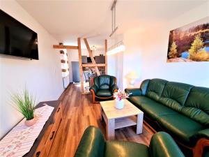 sala de estar con sofá verde y sillas en Ferienhaus Heider, en Darlingerode
