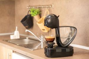 eine Kaffeemaschine auf einer Küchentheke mit einer Tasse Kaffee in der Unterkunft Central Point Apartments in Ruse