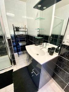 uma casa de banho com um lavatório, um chuveiro e um espelho. em La Caudalie 