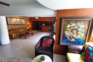 a living room with a couch and a painting on the wall at Grand Hotel Colonial Cancun in Cancún